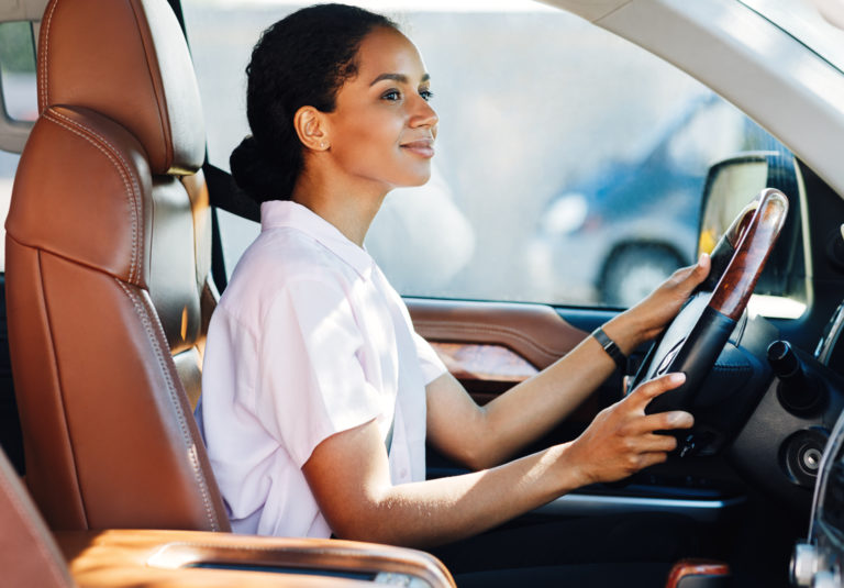 woman smiling while driving - improve your driving skills