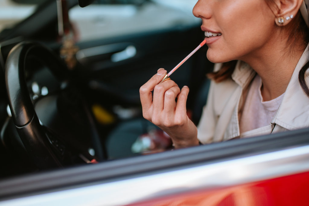 woman doing her makeup in car
