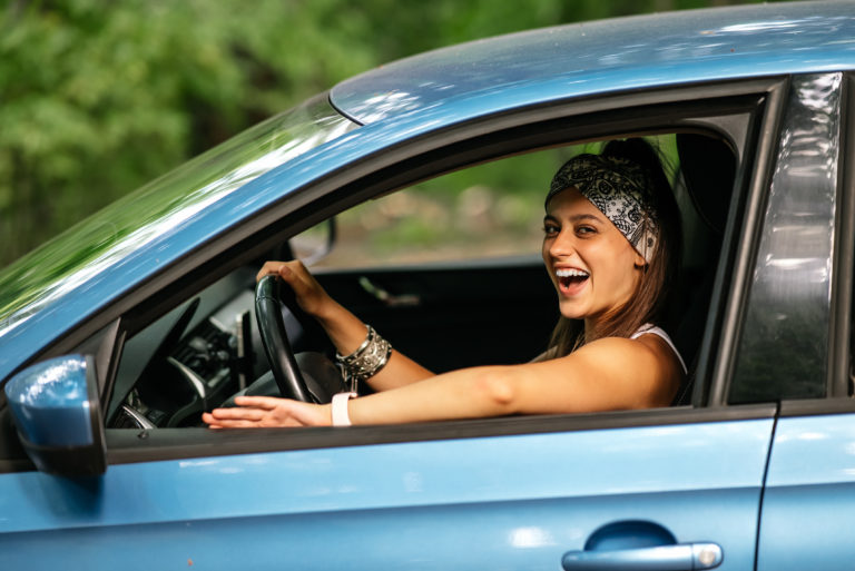 girl having fun in her car -- fun things to do when you get your first car
